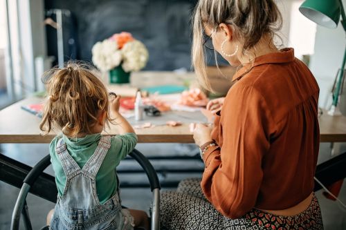 Mother and daughter making flowers of paper